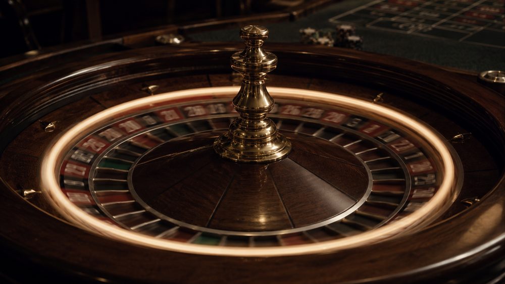 A long exposure of a roulette ball travelling the track so that it becomes a continuous ring of light above the sharp wheel